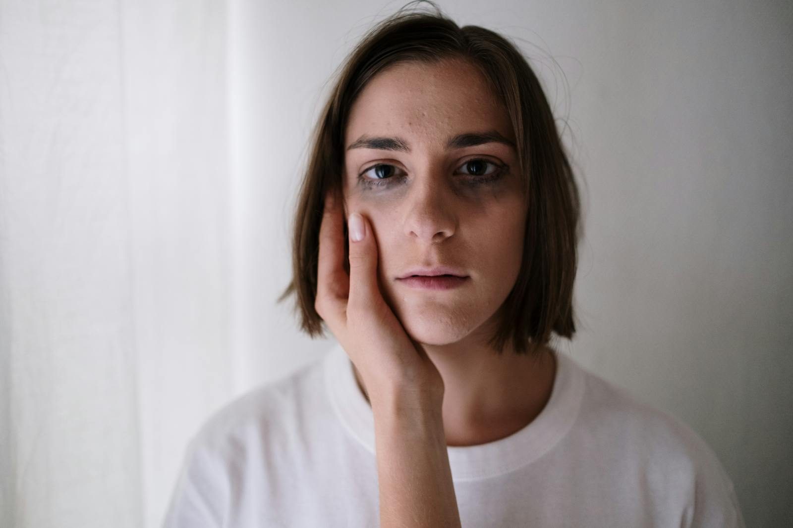 Close-up of a young woman with an introspective expression, emphasizing mental health themes.